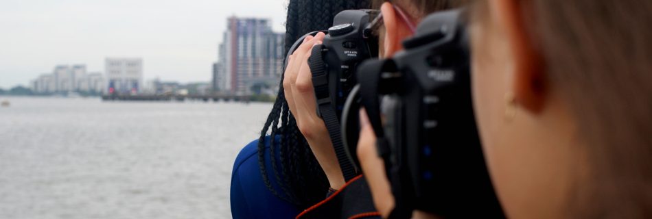 Photograph of three people using cameras to take pictures at the same landscape