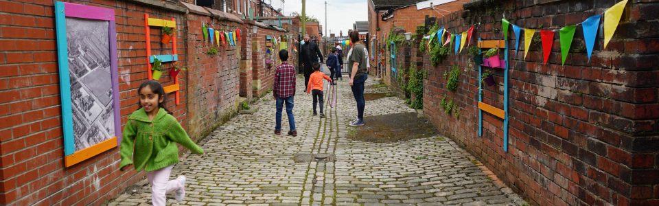 Photograph of a community project by Rhiannon Ashley. Depicting a road where kids and adults are playing.