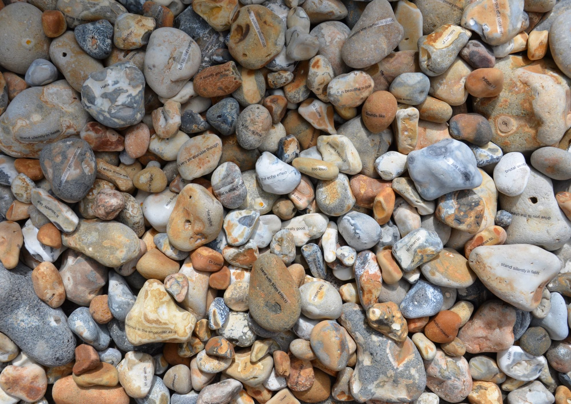 Universal Crepitation Featured Image - Photograph of stones with text on them, light shining on them from the right